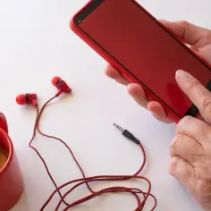 Czerwony telefon, słuchawki i filiżanka kawy. Czy warto dopłacać za pierwsze miejsce w rankingu jakości dźwięku?