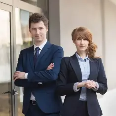 Dwóch prawników w garniturach stoi przed budynkiem.