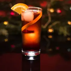 Elegancki drink z pomarańczą i lodem, idealny sposób, jak pić Campari w świątecznej atmosferze.
