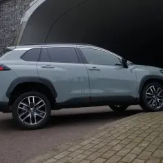 Szary Toyota Corolla Cross na tle tunelu. Czy warto kupić? Sprawdź opinie!