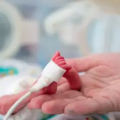 Delikatna stópka noworodka w inkubatorze, z opatrunkiem i sondą. W którym tygodniu najczęściej rodzi się pierwsze dziecko?