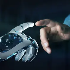 Dłoń robota i ludzki palec zbliżają się do siebie, symbolizując przyszłość, gdzie sztuczna inteligencja za darmo otwiera nowe możliwości.