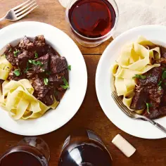 Dwa talerze z wołowiną po burgundzku, podaną z tagliatelle. Aromatyczne danie, które zachwyci każdego miłośnika klasyki.