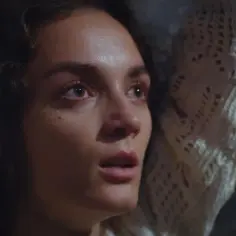 Twarz młodej kobiety, pełna emocji, w białym, dzianinowym szalu. Scena z serialu "Dziedzictwo", turecki serial.