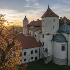 Zamek w Wiśniczu o zachodzie słońca, otoczony jesienną drzewami. To jedna z najpiękniejszych atrakcji Małopolski.