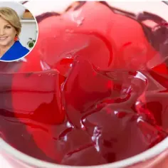 Czerwona galaretka w pucharku, obok uśmiechnięta kobieta. Dowiedz się, ile godzin tężeje galaretka, by cieszyć się deserem.