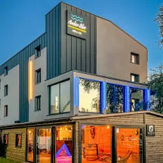 Nowoczesny budynek Amber Blue Wellness & Spa z neonowym oświetleniem i drewnianą częścią barową.
