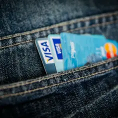 Dwie karty Visa i karta Mastercard Paypass schowane w kieszeni jeansów. Wygodna karta przedpłacona na codzienne zakupy.