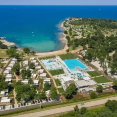 Idealne wakacje nad morzem z dziećmi: kompleks basenów, plaża i domki kempingowe w otoczeniu zieleni.
