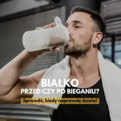 Mężczyzna w siłowni pije białko z shakera, z ręcznikiem na szyi.