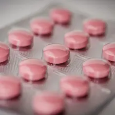 Blister opakowania z różowymi tabletkami. Jedna z nich, jak oksykodon, może przynieść ulgę w bólu.