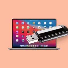 Jak znaleźć pendrive na laptopie? Czarny pendrive leży na ekranie MacBooka z widocznymi ikonami aplikacji.