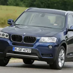 Ciemnoniebieskie BMW X3 na drodze, idealne do rodzinnych wyjazdów. Wiele pozytywnych bmw x3 opinie potwierdza jego wszechstronność.
