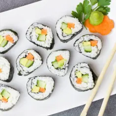 Talerz sushi z awokado, ogórkiem i marchewką. Czy sushi jest kaloryczne? To zależy od składników, ale te warzywne rolki są lekkie.