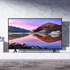 Nowoczesny salon z telewizorem 65 cali, oczyszczaczem powietrza i wentylatorem.
