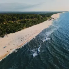 Malowniczy klif w Jastrzębiej Górze z widokiem na piaszczystą plażę i Bałtyk.
