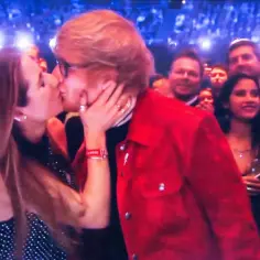 Ed Sheeran całuje swoją żonę, Cherry Seaborn, podczas koncertu.