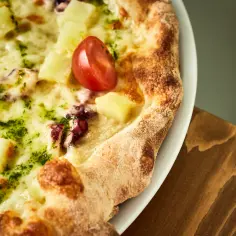 Pyszna pizza z owocami morza, ananasem i pomidorkiem, obficie posypana serem. Jaki ser na pizzę wybrać, by uzyskać taki efekt?