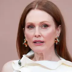 Julianne Moore, znana aktorka, w białej kreacji i efektownych złotych kolczykach.