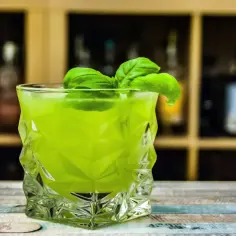 Zielony koktajl z bazylią w szklance. Czy można zastąpić świeżą miętę syropem w domowym mojito?