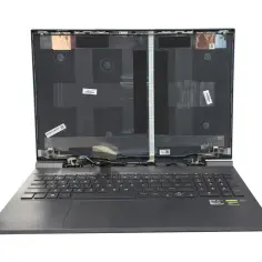 Otwarty laptop z widoczną klawiaturą i taśmami przygotowanymi do wymiany matrycy.