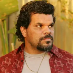 Luis Guzmán w filmach, serialach i programach. Aktor z charakterystyczną brodą i kręconymi włosami w czerwonej koszuli.