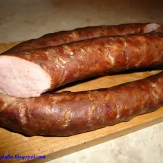 Wędzona kiełbasa, której smak przywołuje stary przepis. Pokrojony kawałek ukazuje soczyste, różowe wnętrze.