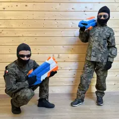 Dzieci w strojach żołnierzy, jeden kuca z pistoletem na wodę, drugi stoi z takim samym. Strój Piłsudskiego dla dziecka gotowy do zabawy!