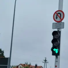 Sygnalizacja świetlna z zieloną strzałką w lewo i znakiem "zakaz zawracania", który nie dotyczy samochodów osobowych i jednośladów.