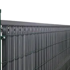 Praktyczne pasy do płotu, czym zasłonić płot od sąsiada. Szare lamele na zielonej siatce.