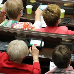 Posłowie w Sejmie głosują, podnosząc ręce i naciskając przyciski na tabletach. Trwa reasumpcja głosowania.