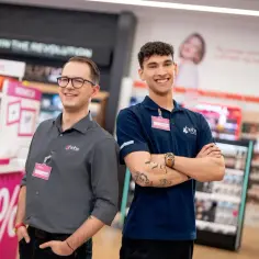 Dwóch uśmiechniętych pracowników Hebe, Alan i Damian, w sklepie. Ciekawe, ile zarabia kierownik Hebe, gdy pracuje się w tak miłej atmosferze.