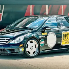 Czarny Mercedes R-klasy z naklejkami "OPTIMA BATTERIES", "WEISTEC ENGINEERING" i "AMG". R63.