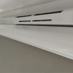 Białe wywietrzniki w oknach zapewniają świeże powietrze w pomieszczeniu.