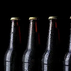 Krople wody na butelkach piwa pszenicznego. Zastanawiasz się nad przyczynami bólów głowy po piwach pszenicznych u niektórych osób?