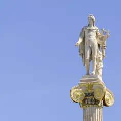 Kamienna rzeźba Apollina, brata Artemidy, z lirą w dłoni, na ozdobnej kolumnie pod błękitnym niebem.