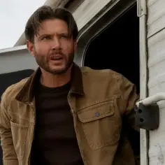 Jensen Ackles w brązowej kurtce wychodzi z przyczepy. Jego role w serialach i programach zapadają w pamięć.