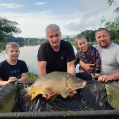 Rodzina cieszy się udanym połowem karpia nad zalewem rejowskim.