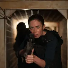Kate Macer z filmu Sicario 3 celuje z broni w ciemnym korytarzu, gotowa do akcji.