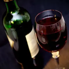 Butelka i kieliszek czerwonego wina. Zapach octu lub zmywacza do paznokci to objawy zepsutego wina.