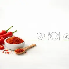 Czerwone papryczki chili i ich proszek. Czy ostre jedzenie jest zdrowe? Ikony serca, talerza, liścia i ognia sugerują odpowiedź.