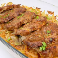 Pieczona karkówka z cebulą w naczyniu żaroodpornym. Idealne rozwiązanie, co zrobić z resztkami pieczonej karkówki, by znów zachwycić smakiem.