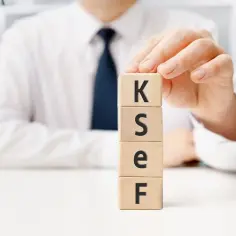 Dłoń układa kostki z literami K, S, E, F. To klucz do tego, jak sprawdzić ilość pracowników w firmie.
