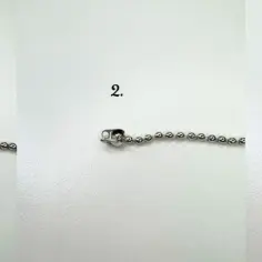 Trzyetapowy pokaz zapinania srebrnej bransoletki z koralików.
