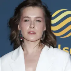 Anna Maria Sieklucka w białej marynarce, z dużymi kolczykami, na tle logo Polsat.