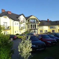 Willa Global w Jastrzębiej Górze z parkingiem pełnym samochodów.