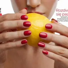 Dłonie z czerwonymi paznokciami trzymają cytrynę. Tekst informuje o problemie pękających paznokci i jego leczeniu.