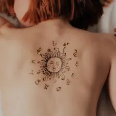 Tatuaż słońca z symbolami zodiaku na plecach. Może to symbolizować ascendent w koziorożcu, dążenie do celu i stabilność.