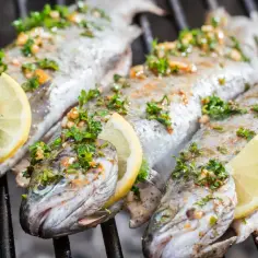 Pstrągi na grillu, przyprawione ziołami i cytryną. Idealna ryba na grilla, która zachwyci smakiem.
