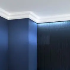 Elegancki biały pasek pod sufitem dodaje uroku granatowym ścianom i podkreśla nowoczesny charakter wnętrza.